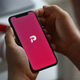 A photo of a cellphone displaying the Parler logo.
